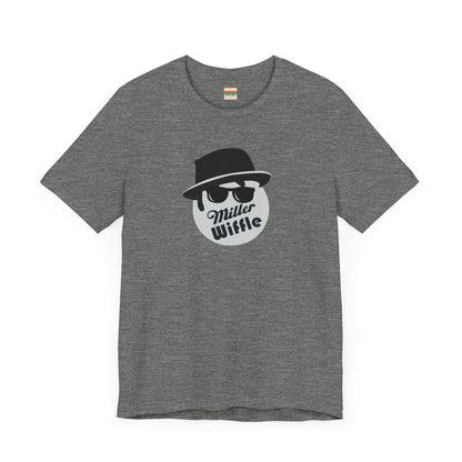 A purple unisex jersey tee from Printify, named the "Miller Wiffel Ball - Blues Brothers - Unisex Jersey Short Sleeve Tee," features a stylized graphic of a ball wearing a black fedora and sunglasses with the text "Miller Wiffel" below it. Another identical soft cotton t-shirt is neatly folded underneath, highlighting its breathable fabric.