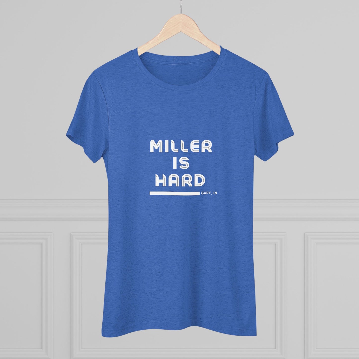 The Miller is Hard - Miller Beach Women's Triblend Tee by Printify features unique red coloring with white text that reads "MILLER IS HARD" and "GARY, IN" below, showcasing distinctive lettering spacing and alignment. Made from ultra-soft fabric, this shirt ensures a comfortable fit with a simple, casual design.