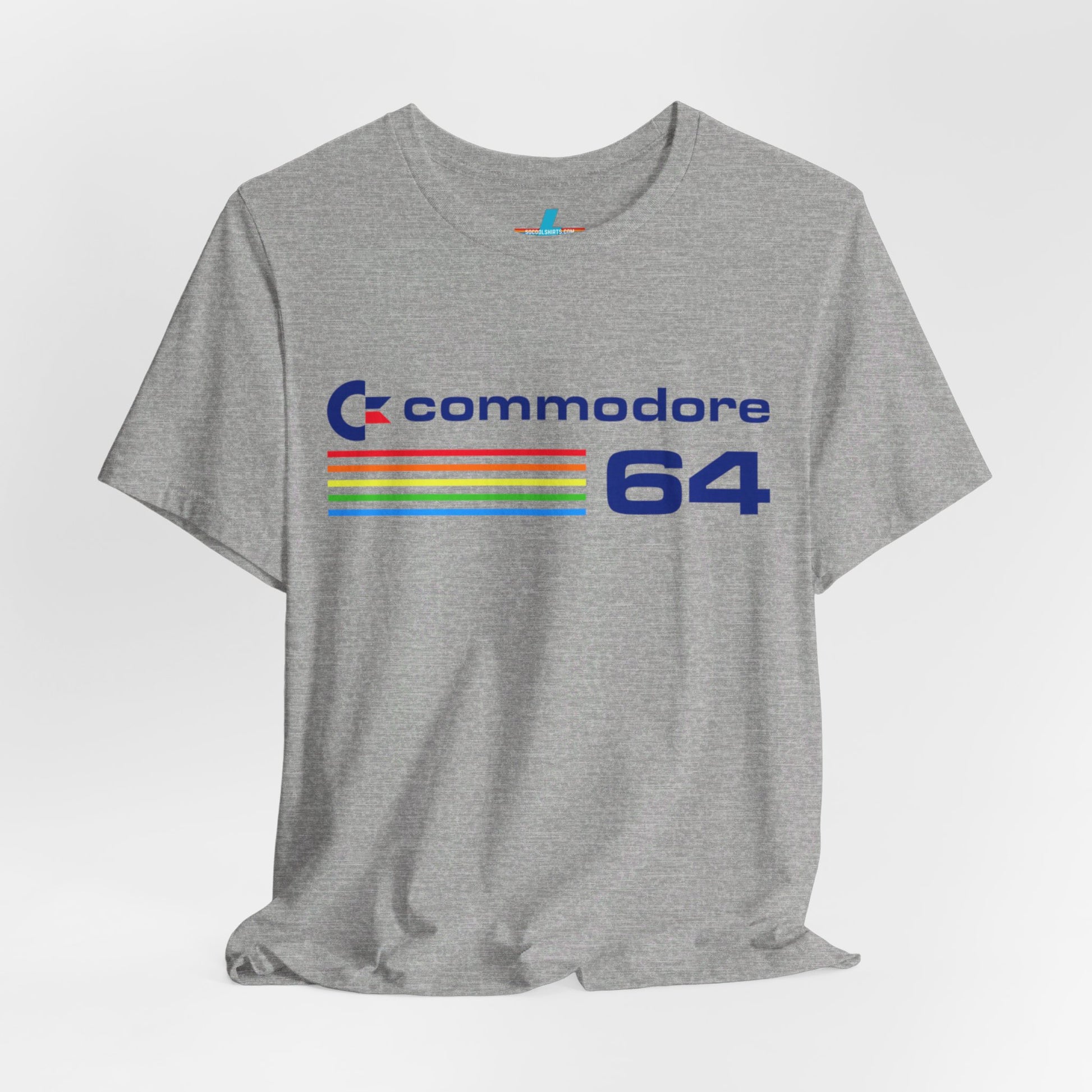 The 1980s Commodore 64 Computer C64 Unisex Jersey Short Sleeve Tee from Printify features a green T-shirt adorned with a vintage design showcasing the text "Commodore 64" and multicolored horizontal lines next to it. The word "Commodore" is emblazoned in blue alongside the Commodore logo, while the number "64" is also highlighted in blue on the right. Ideal for any retro tech enthusiast, this shirt is displayed against a white background.