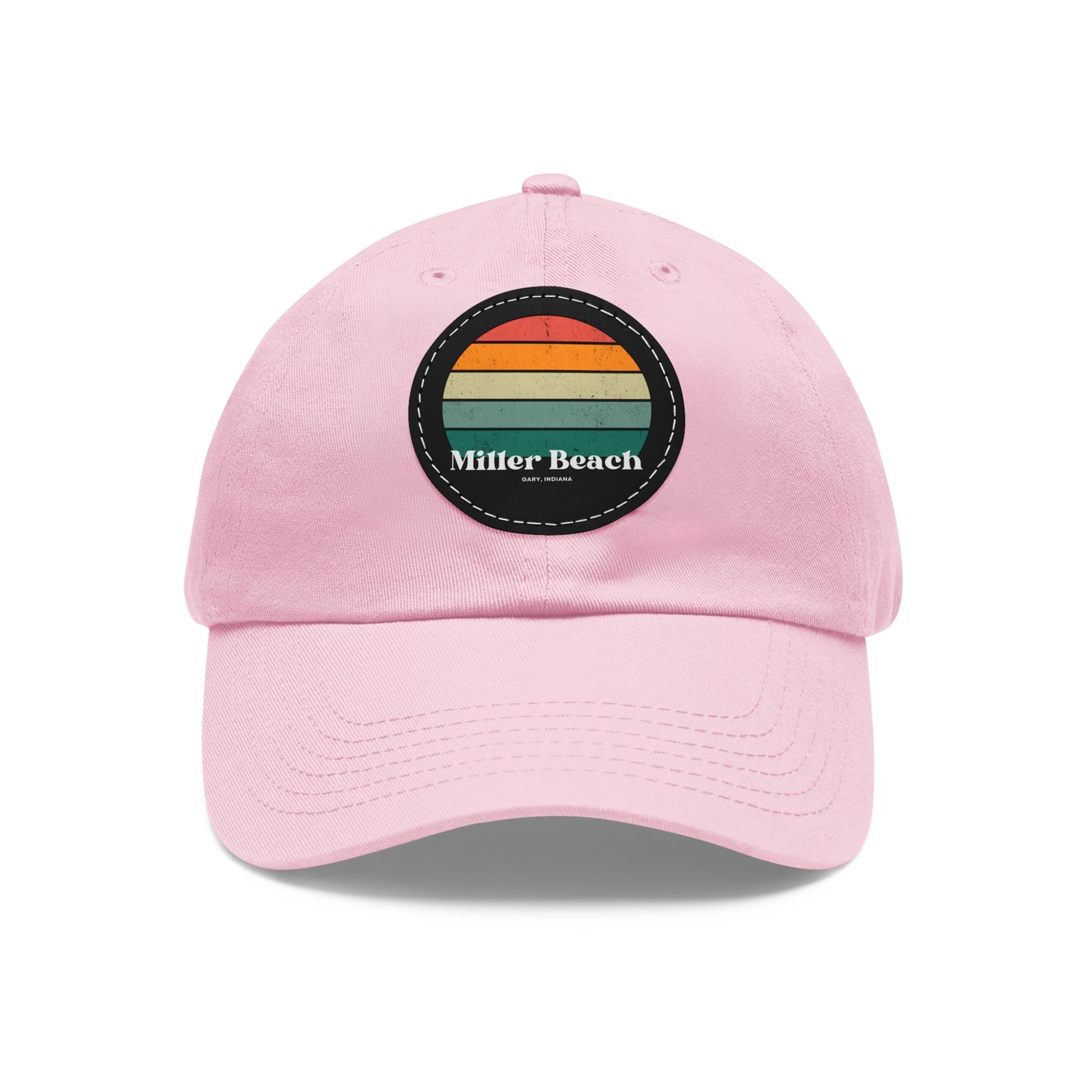 The Miller Beach Retro Sunset - Dad Hat with Leather Patch (Round) by Printify is a pink baseball cap crafted from bio-washed chino twill for added comfort. It features a PU leather patch adorned with horizontal stripes in red, orange, yellow, green, and blue. Below the stripes, "Miller Beach" is embroidered in white. An adjustable strap at the back ensures a perfect fit.