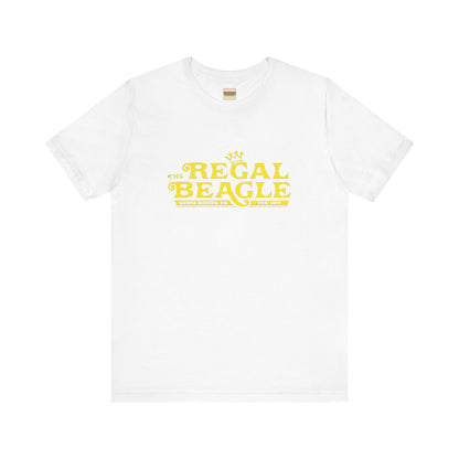 The Printify Regal Beagle - Three's Company Unisex Jersey Short Sleeve Tee, in black, showcases "The Regal Beagle, Santa Monica, CA, Est. 1977" text in a yellow vintage-style font. Crafted from 100% Airlume combed cotton for superior comfort.