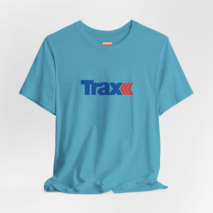 A gray unisex jersey short sleeve tee from Printify, inspired by retro 1980s Kmart style. The "Trax" logo is printed in blue letters, followed by three red arrows pointing to the right. This classic Trax Brand T-shirt is laid flat against a white background, capturing nostalgic fashion vibes.