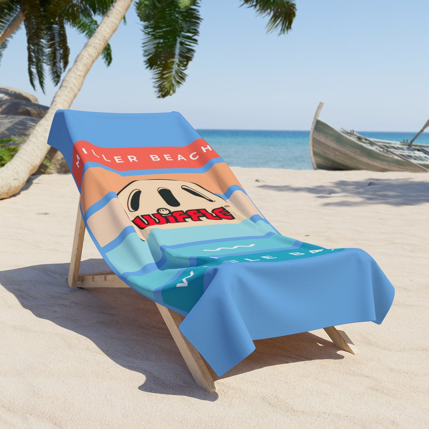 A wooden lounge chair with a luxurious Printify Miller Beach Wiffel Ball - Sunset Beach Towel draped over it sits on a sandy beach. The towel features a design with the words "KILLER BEACH," a cartoon wiffel, and waves. Palm trees, a boat, and a clear blue sea are visible in the background under a bright sky.