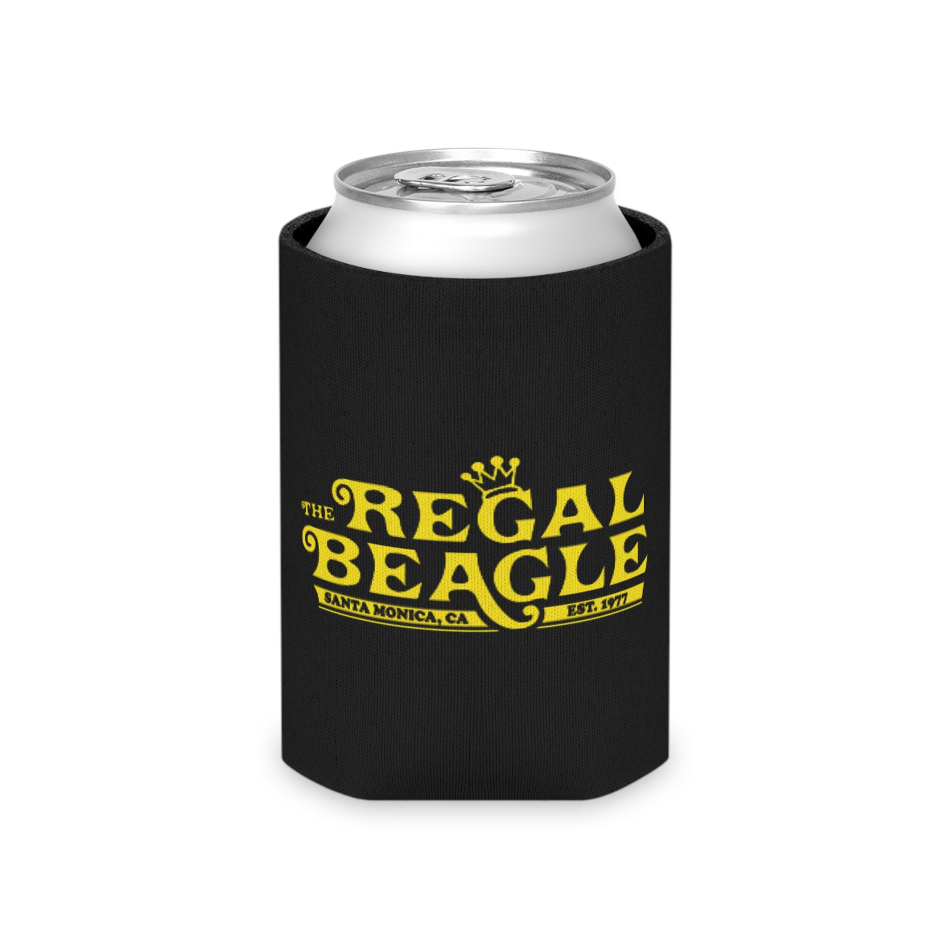 The Regal Beagle - Three's Company - Koozie by Printify features a black design with yellow text that reads "The Regal Beagle," alongside "Santa Monica, CA" and "Est. 1977." A small, partially visible URL in white and blue at the bottom reads socoolshirts.com. An ideal accessory for fans of Three’s Company!