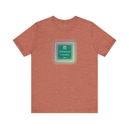 Introducing "The Lebanon Loop - Indiana" unisex jersey short sleeve tee by Printify. This green t-shirt features a graphic of a road sign displaying "39 Lebanon Lizton 1 MILE" within a slightly glowing square frame. It's crafted from 100% Airlume cotton and photographed flat on a white background.