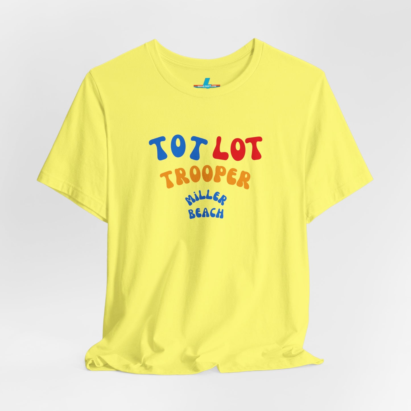 A green unisex jersey short sleeve tee from Printify, featuring colorful text on the front that reads "TOT LOT TROOPER MILLER BEACH" in blue, red, yellow, and orange letters. The shirt is displayed against a plain white background.