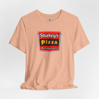 A black Shakey's Pizza - 1980s Retro Logo - Unisex T-Shirt by Printify hangs against a white background. The shirt features a colorful graphic with the text "Shakey's Pizza Restaurant" in white, yellow, and black lettering on a red background, resembling vintage pizza joints signage. This retro tee brings nostalgic vibes of classic pizzerias.