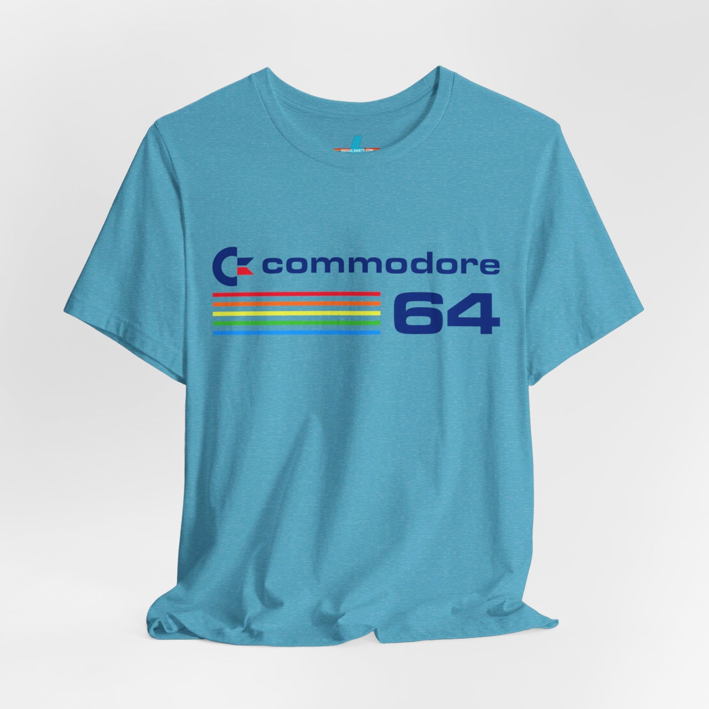 The 1980s Commodore 64 Computer C64 Unisex Jersey Short Sleeve Tee from Printify features a green T-shirt adorned with a vintage design showcasing the text "Commodore 64" and multicolored horizontal lines next to it. The word "Commodore" is emblazoned in blue alongside the Commodore logo, while the number "64" is also highlighted in blue on the right. Ideal for any retro tech enthusiast, this shirt is displayed against a white background.