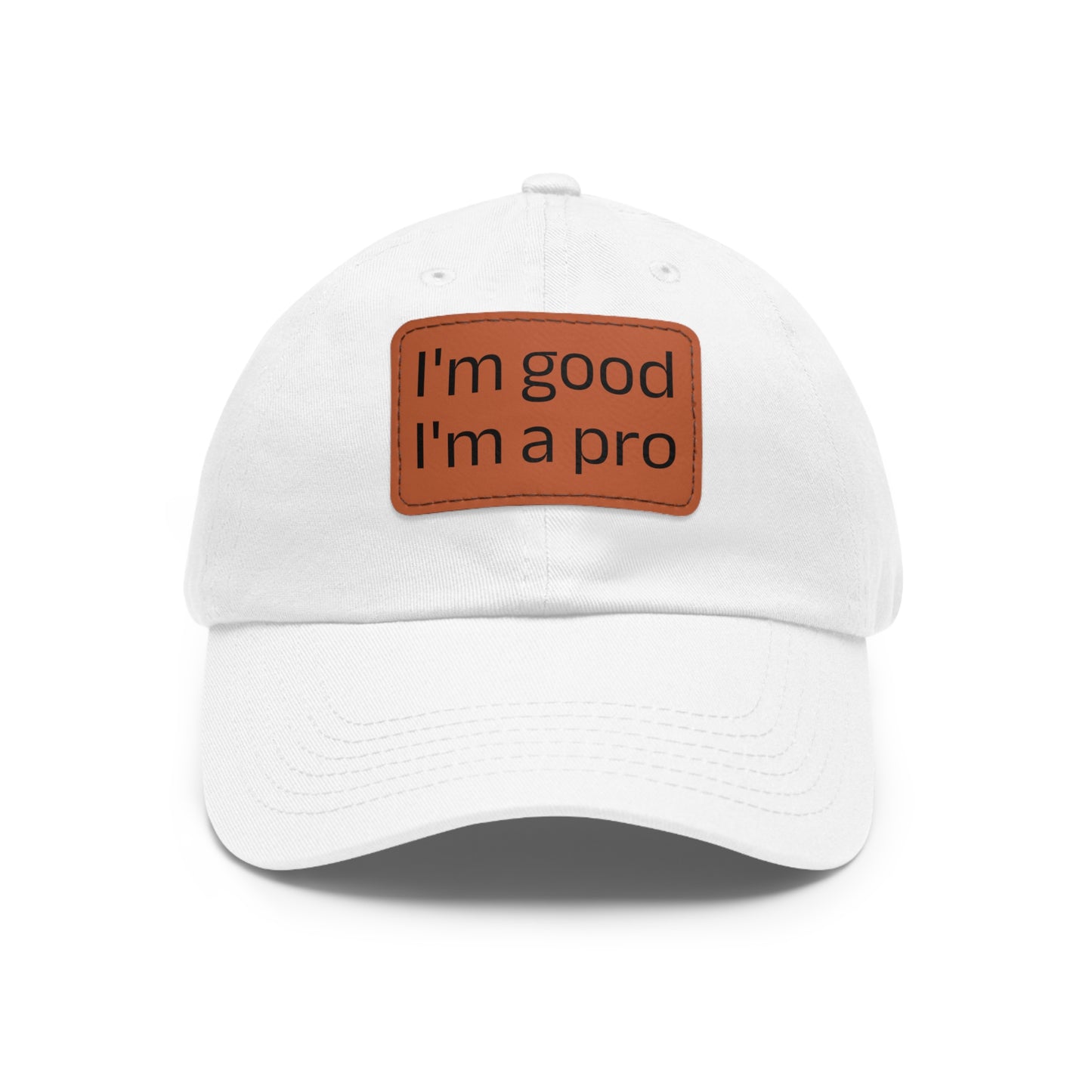 The Printify Dad Hat with Leather Patch (Rectangle) is a black, six-panel low-profile baseball cap made from bio-washed chino twill. This personalized Dad hat features a curved brim, visible stitching details, and a rectangular leather patch on the front that reads "I'm good I'm a pro" in grey text.