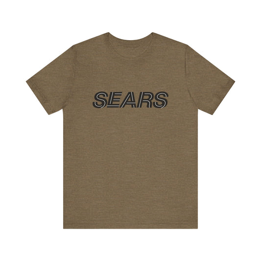 The Printify Sears Stores 1984 Logo - Unisex Jersey Short Sleeve Tee is a plain brown T-shirt featuring "SEARS" printed in large, black, and outlined letters across the chest. Crafted from lightweight cotton, this sustainable casual wear tee offers everyday comfort for all.