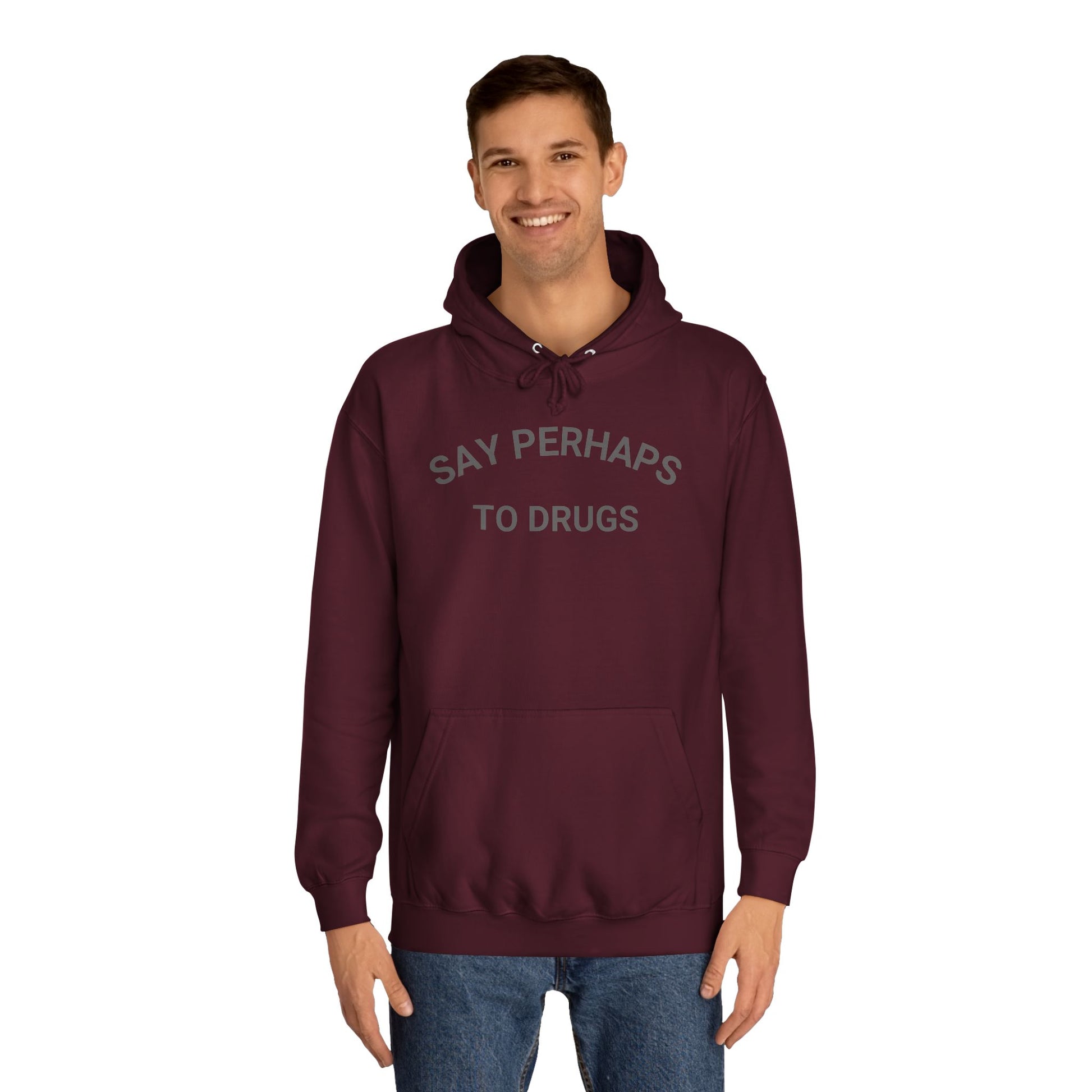 The "Say Perhaps to Drugs - Unisex College Hoodie" by Printify is a maroon hoodie made from soft Airlume cotton. It showcases the phrase "SAY PERHAPS TO DRUGS" in gray across the chest, and features a collegiate design with a front pocket and drawstring hood for enhanced comfort and style.