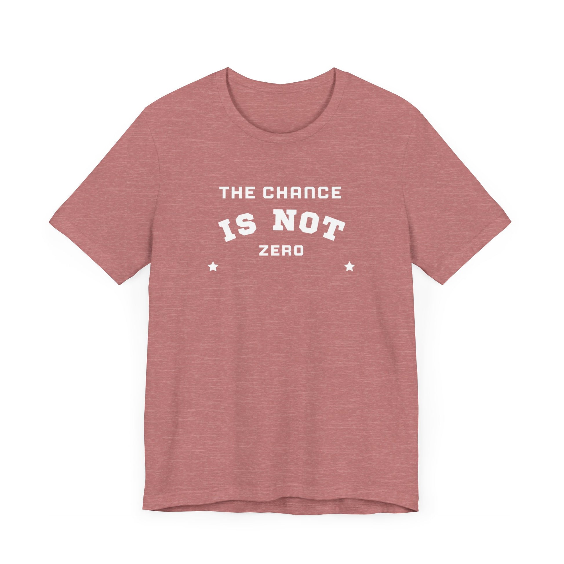 Folded light red Unisex Jersey Short Sleeve Tee from Printify, featuring bold white text that reads "THE CHANCE IS NOT ZERO" along with two star illustrations. This motivational T-shirt, made from breathable fabric, is neatly stacked with another identical shirt underneath.