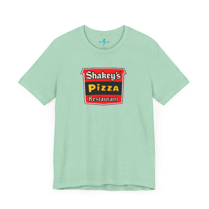 A black Shakey's Pizza - 1980s Retro Logo - Unisex T-Shirt by Printify hangs against a white background. The shirt features a colorful graphic with the text "Shakey's Pizza Restaurant" in white, yellow, and black lettering on a red background, resembling vintage pizza joints signage. This retro tee brings nostalgic vibes of classic pizzerias.