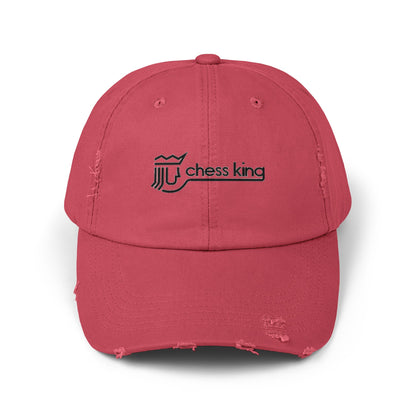 The 1980s Chess King Clothing Store Logo - Unisex Distressed Cap by Printify is a beige baseball cap made from 100% cotton twill. It features intentional distress details and a logo with a crown and rook piece, along with the text "chess king" embroidered on the front, making it a stylish choice for custom caps enthusiasts.