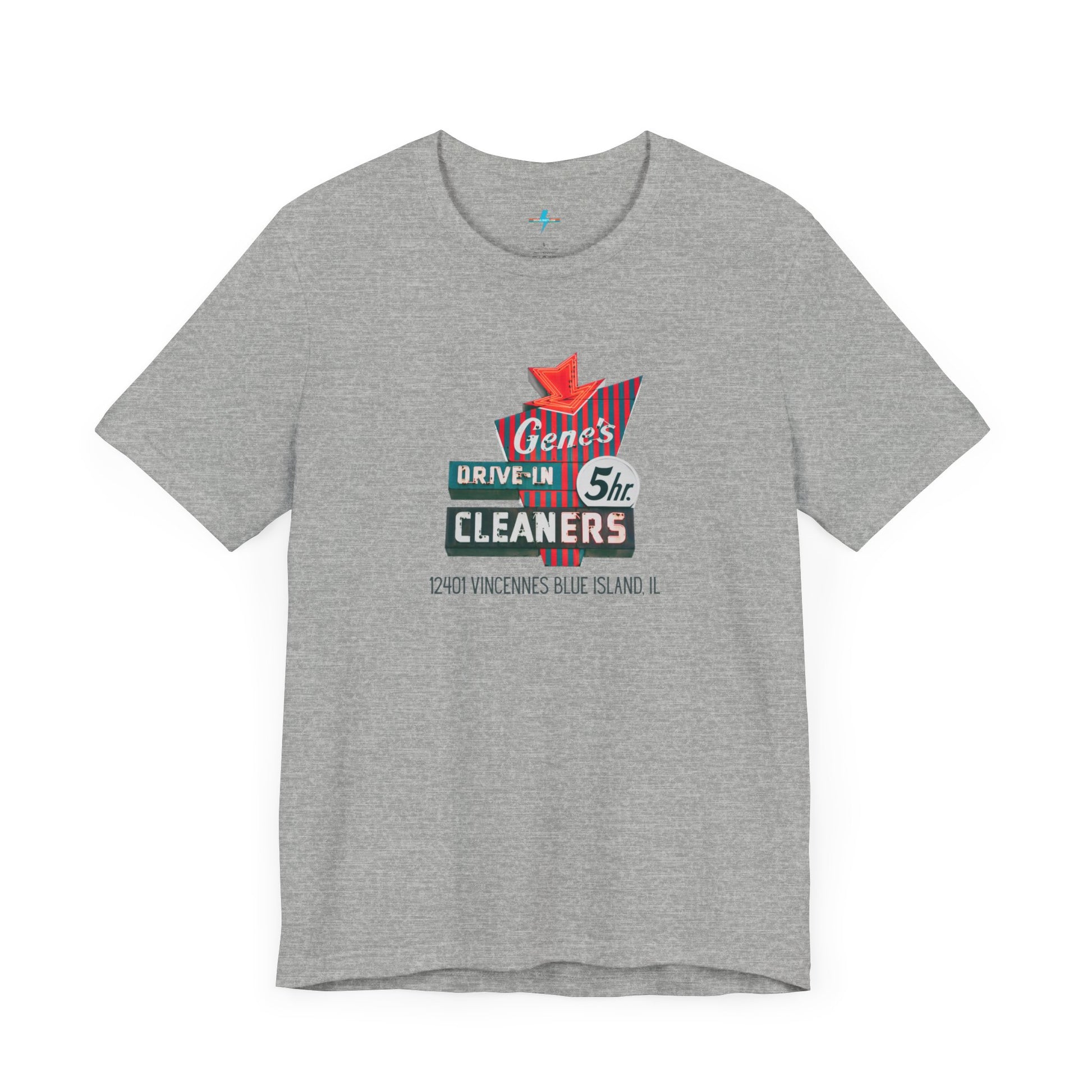 A unisex Jersey short sleeve tee from Printify featuring a light grey color with a retro-style graphic in the center. The design showcases text that reads "Gene's Drive In Cleaners, 5th," along with the address "12401 Vincennes Blue Island IL" in a blend of vintage fonts and colors, evoking the classic Chicago Fire-era vintage sign aesthetic.