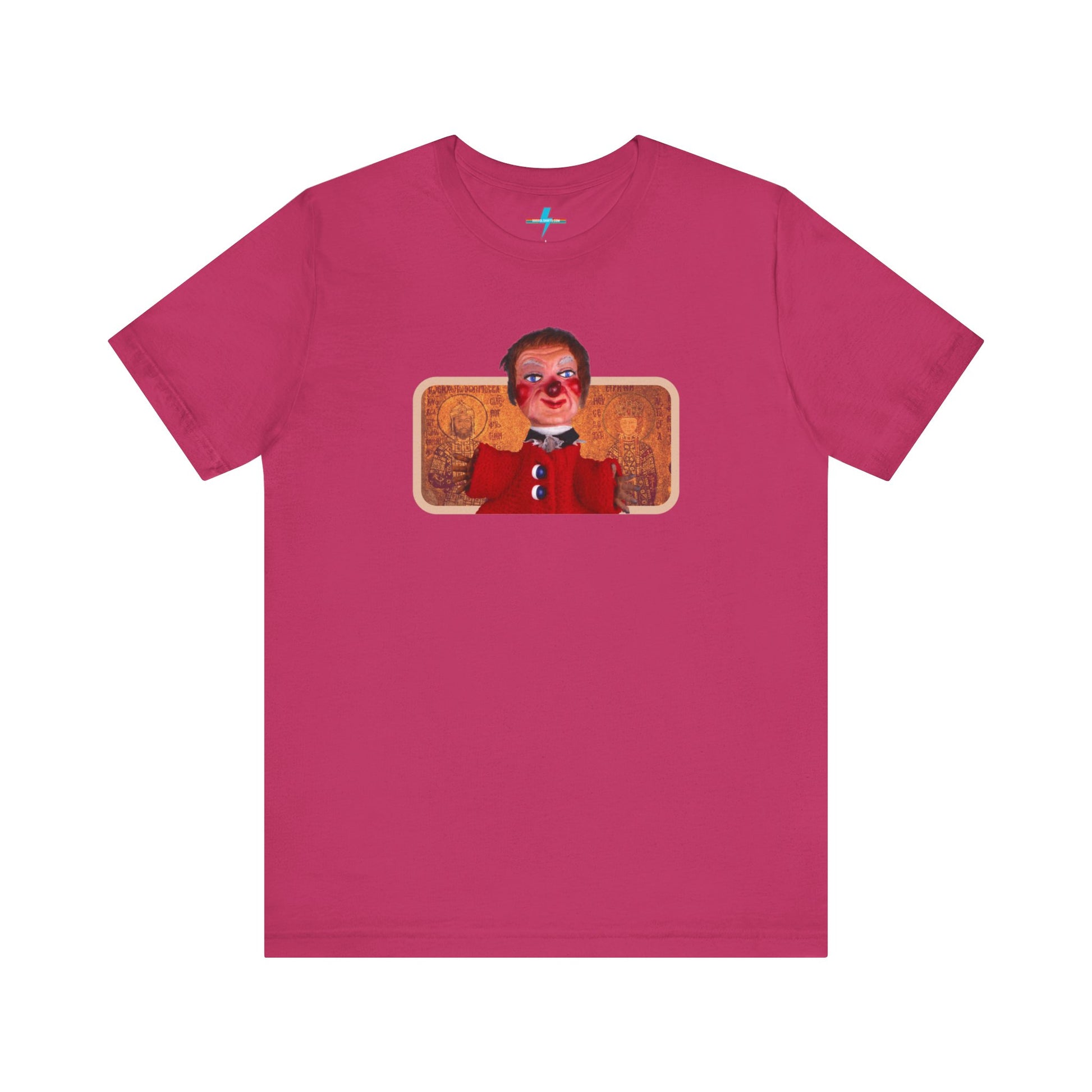 The rust-colored Printify Lady Elaine - Mr. Rogers Unisex Jersey Short Sleeve Tee features a detailed image of the Lady Elaine puppet, dressed in a red outfit with a painted face, set against an intricate artistic backdrop. The centrally positioned puppet and vivid colors create a striking contrast against the muted tone of the shirt, evoking nostalgic memories of Mr. Rogers' Neighborhood.