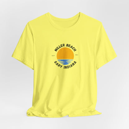 The Miller Beach Gary Indiana EST 1851 - Unisex Jersey Short Sleeve Tee by Printify is a classic blue unisex shirt featuring a vibrant graphic design of a yellow sun setting over blue waves. The text surrounding the artwork reads "Miller Beach" at the top and "Gary Indiana" at the bottom, making it an ideal tribute to this cherished location.