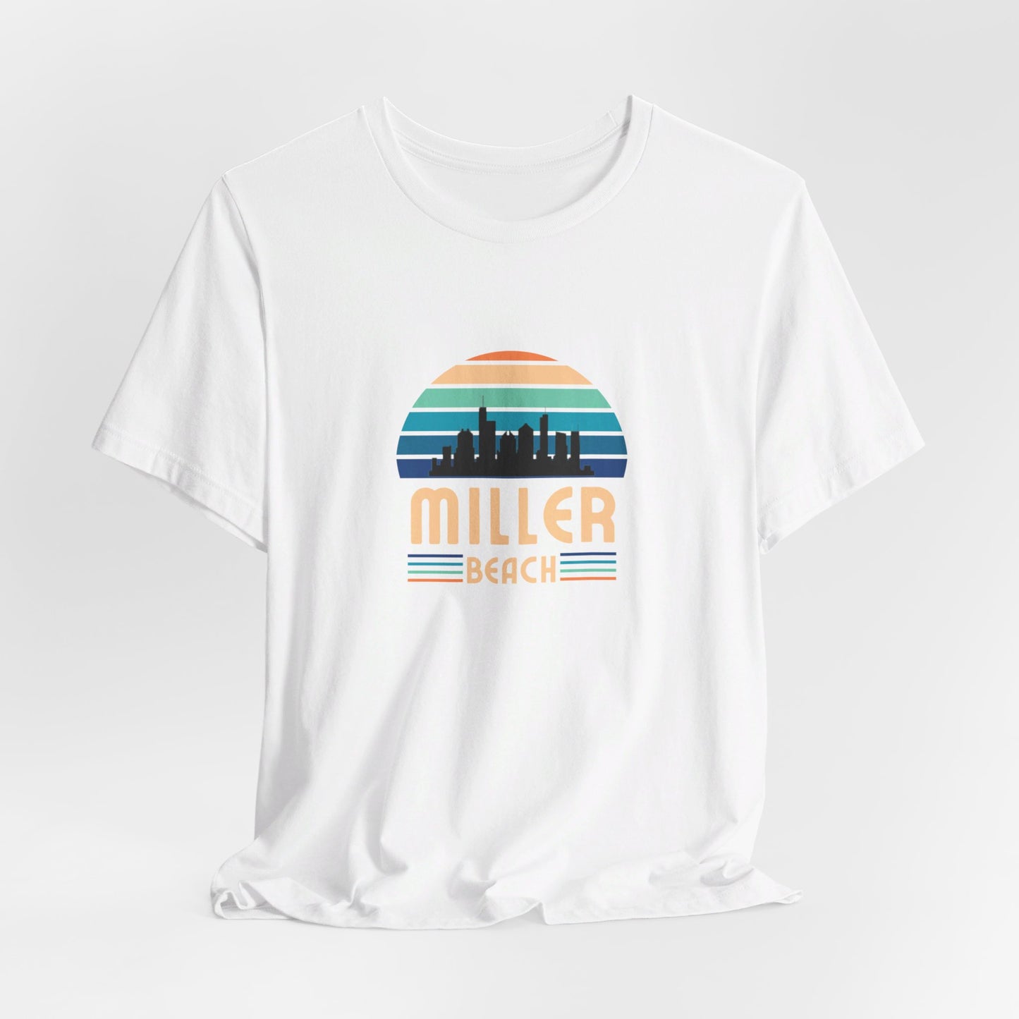 The Printify Miller Beach Chicago Skyline - Unisex Jersey Short Sleeve Tee is a light blue T-shirt featuring a stylized graphic of the Chicago skyline against a setting sun with gradient shades of blue and orange. Below the graphic, "Miller Beach" is printed in bold, yellow letters.