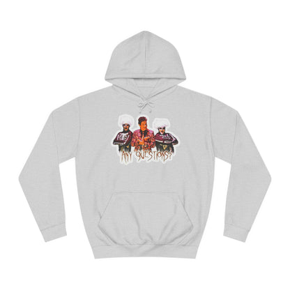 The David S Pumpkins - Any Questions? - Halloween Unisex College Hoodie by Printify is a brown sweatshirt showcasing an illustration of three people. The central figure has red hair, sports a colorful ensemble, and emanates a Halloween vibe, with two flanking figures who have white hair and wear dark attire. Beneath the trio is the phrase "Any Questions?