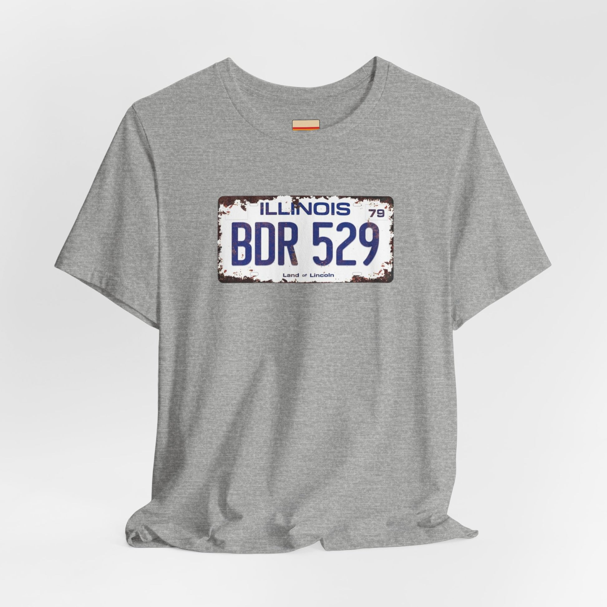 The Printify Blues Brothers BDR 529 License Plate Unisex Jersey Short Sleeve Tee showcases a vintage Illinois license plate graphic with "BDR 529" prominently displayed, as famously seen in the Blues Brothers film. The design includes "Illinois" and "Land of Lincoln" above and below the numbers, with a weathered, rustic look that enhances its retro appeal.