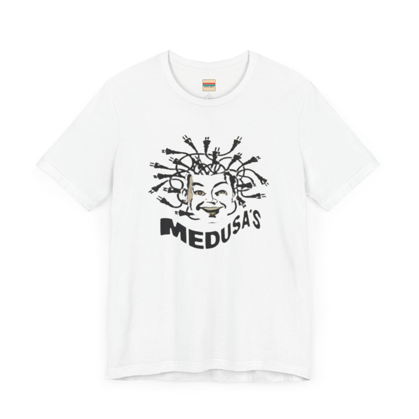 A cream-colored unisex jersey short sleeve tee from Printify, titled "Medusa's 1980s Dance Club Chicago," features a black and white illustration of a cartoonish Medusa head. The soft cotton design showcases numerous snakes as hair with a smiling face. Below, the word "MEDUSA'S" is printed in bold, playful font.