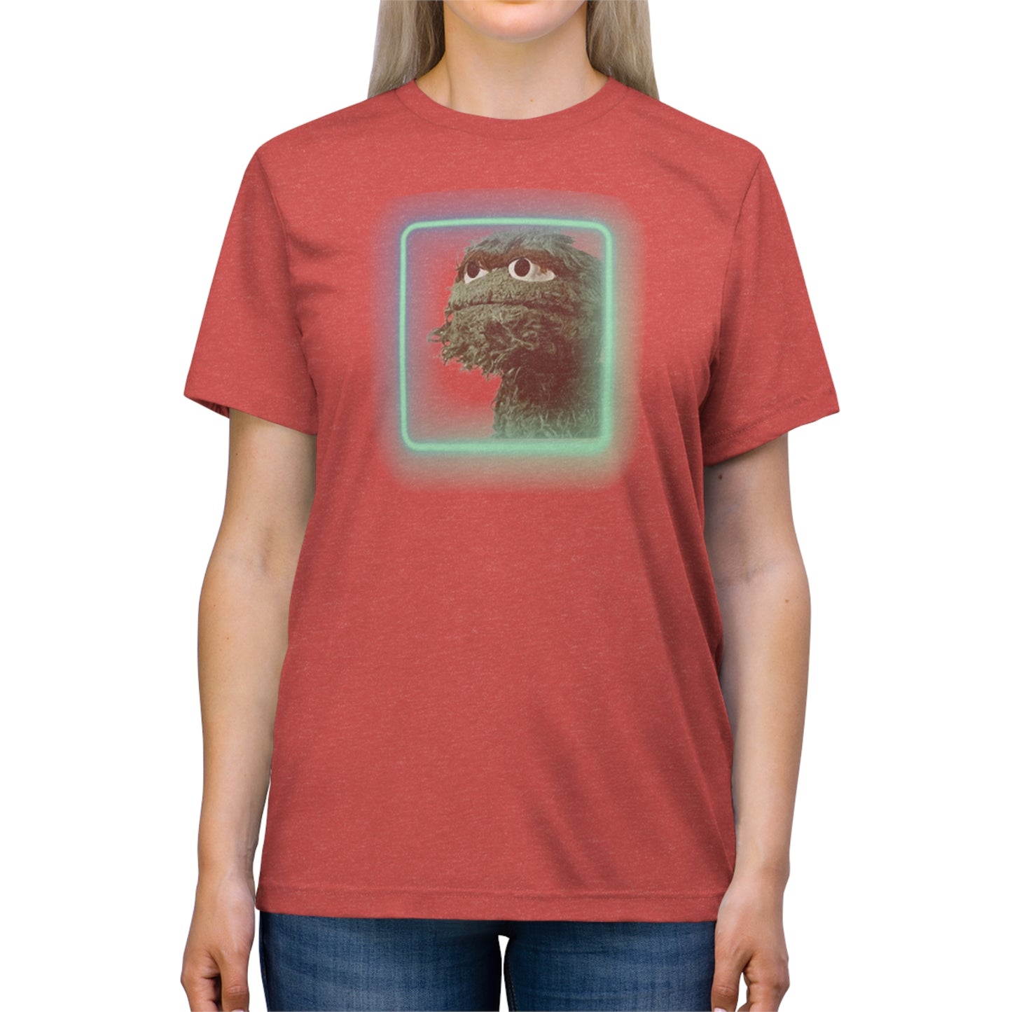 Introducing the Oscar the Grouch Unisex Triblend Tee by Printify: This red triblend t-shirt features a green puppet character with expressive eyes, framed by a glowing, square-shaped rainbow border. With its simple and casual design, free of any additional text or graphics, this tee offers the perfect blend of style and durability thanks to its polyester construction.