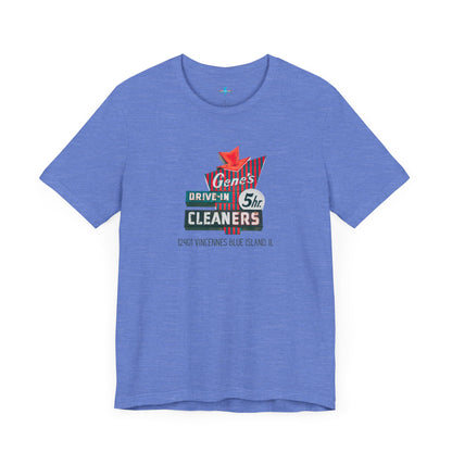 A unisex Jersey short sleeve tee from Printify featuring a light grey color with a retro-style graphic in the center. The design showcases text that reads "Gene's Drive In Cleaners, 5th," along with the address "12401 Vincennes Blue Island IL" in a blend of vintage fonts and colors, evoking the classic Chicago Fire-era vintage sign aesthetic.