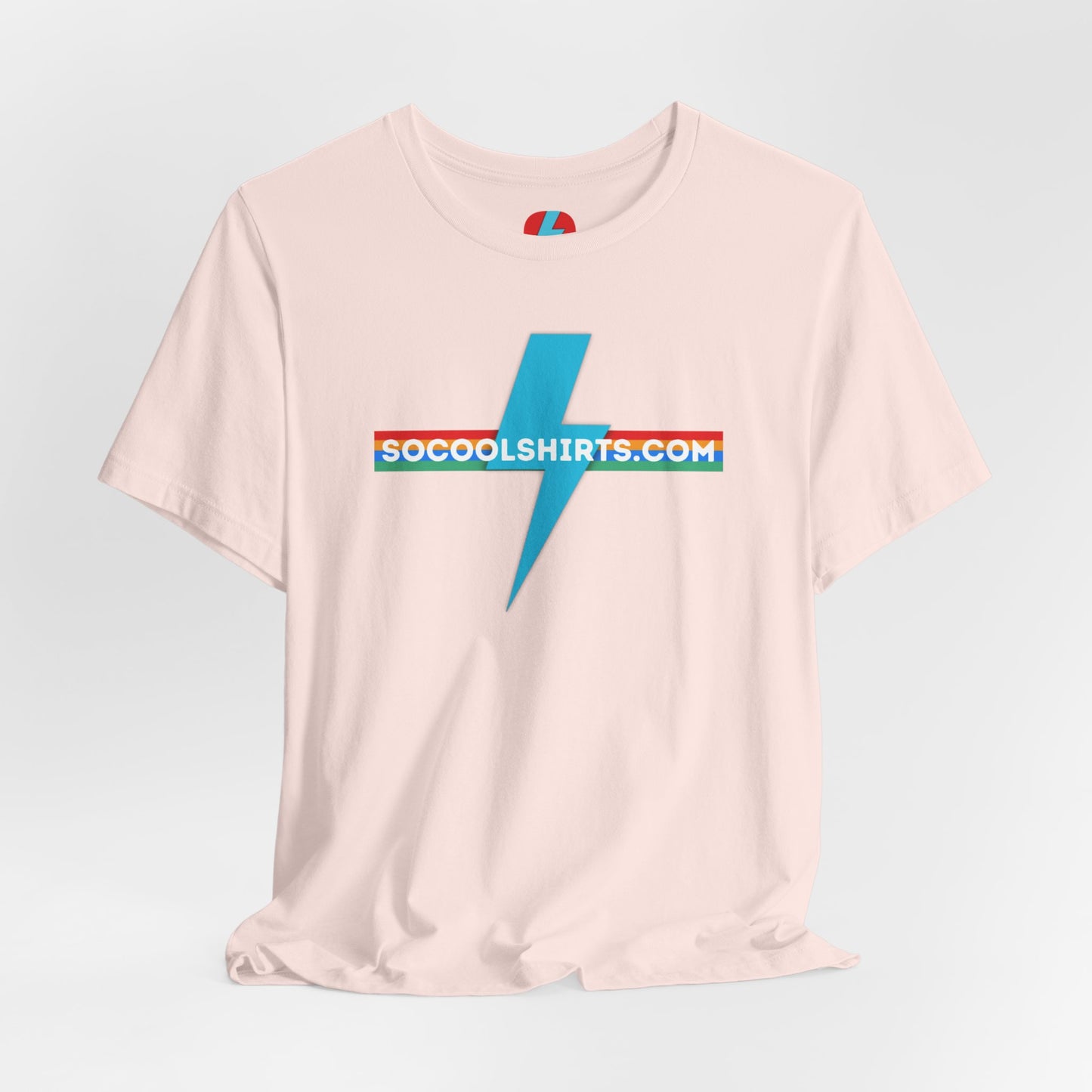 This unisex jersey short sleeve tee by Printify features a striking maroon color with a central light blue lightning bolt design. The text "SOCOOLSHIRTS.COM" is prominently displayed across the lightning bolt in white letters, set against a multicolored background that exudes retro vibes. The shirt is shown laid flat on a white backdrop.