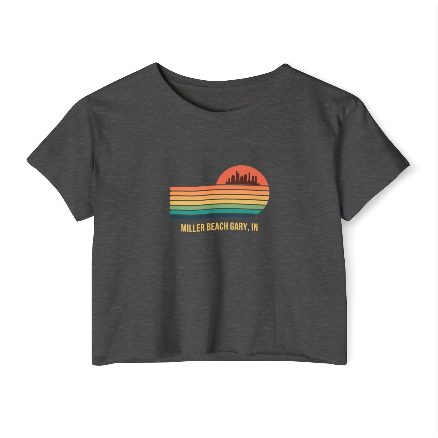 The Miller Beach Gary, IN Gradient Sunset - Women's Festival Crop Top by Printify is a mauve-colored T-shirt showcasing a retro-style graphic design of a sunset with multicolored stripes and a city skyline silhouette. Ideal for festival season, the text below reads "Miller Beach Gary, IN." Crafted to be soft and durable, this custom crop top provides both comfort and style throughout the day.