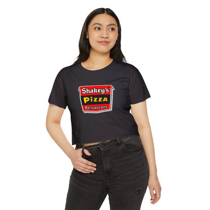 The Shakey's Pizza - Women's Festival Crop Top from Printify is a light blue garment that proudly displays the iconic Shakey's Pizza logo on the chest. Featuring retro-style red and black signage with text in white, yellow, and red that reads "Shakey's Pizza Restaurant," this crop top exudes a vintage-inspired charm.