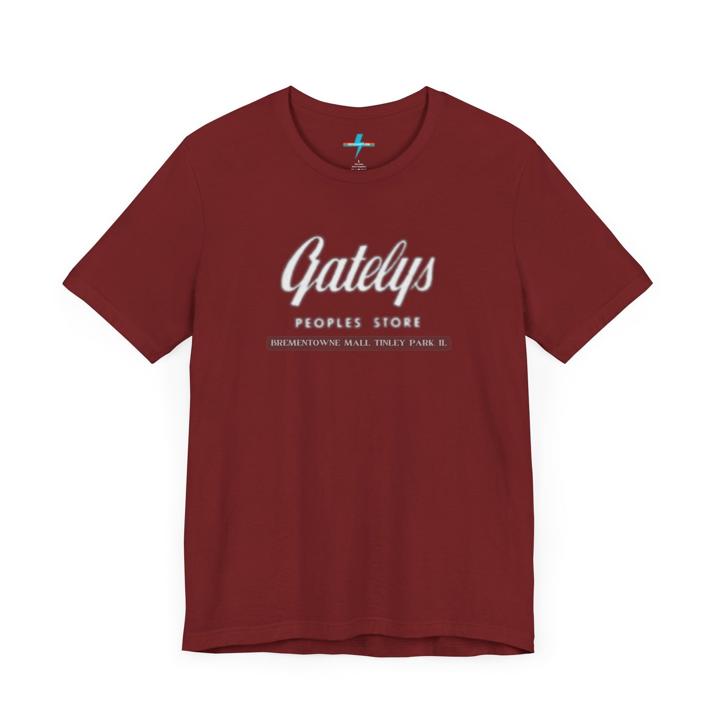 A green unisex jersey short sleeve tee from Printify's SoCool Shirts collection, featuring "Gately's People's Store" printed prominently in white on the front. Below this, smaller text reads "Tinley Park's Brementowne Mall" in white. The T-shirt is displayed against a plain white background and is named the "Gatelys Peoples Store - Vintage 1980s.