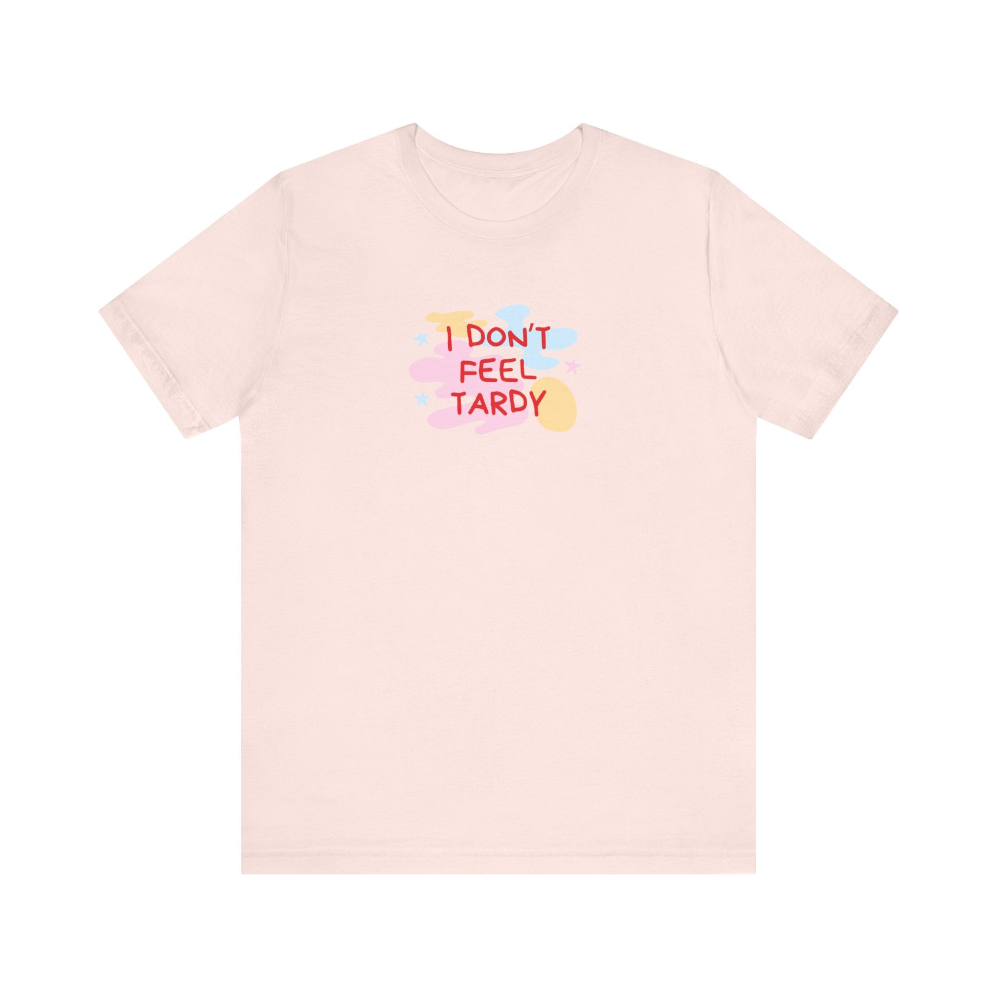 The "I Don't Feel Tardy - 1980s Retro - Unisex Jersey Short Sleeve Tee" from Printify is a light pink jersey shirt that features the bold, colorful text "I DON'T FEEL TARDY" prominently at its center. This design exudes retro vibes with small star shapes and abstract splashes of blue, yellow, and pink, laid flat against a plain background to channel pure Van Halen T-shirt energy.