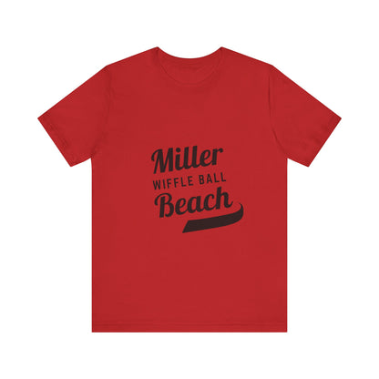 A light blue, soft cotton t-shirt with the text "Miller Beach Wiffel Ball" printed in black on the front. The design features a stylized, curved underline beneath the word "Beach," giving the text a dynamic appearance. This unisex jersey offers a comfortable retail fit for all. Product Name: Miller Beach Wiffel Ball - Unisex Jersey Short Sleeve Tee Retro Logo by Printify.