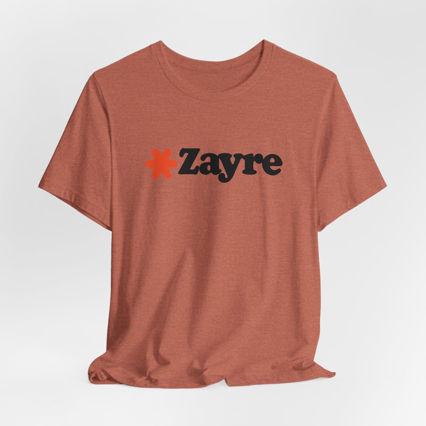 The Zayre Stores Logo - Retro 1980s Unisex Jersey Short Sleeve Tee by Printify features a gray design with the word "Zayre" printed in black letters and a red asterisk preceding the text. Reminiscent of retro fashion from the Zayre 1980s Retail Store, this shirt is displayed against a minimalistic white background and appears to be made of soft, comfortable fabric.