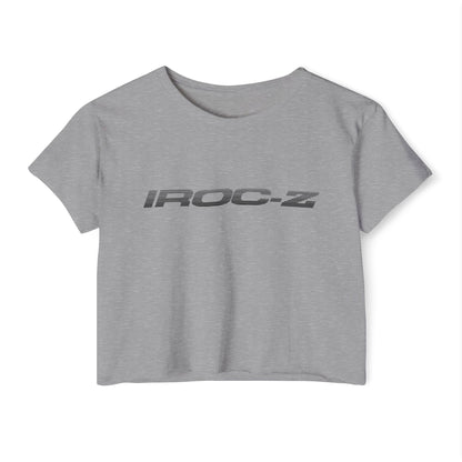 A grey, short-sleeve, rounded-neckline Women's Festival Crop Top by Printify, featuring "IROC-Z" printed in bold black letters across the chest. Perfect for any festival, this Chevrolet Iroc Z-inspired top from the 1980s stands out against a plain white background.