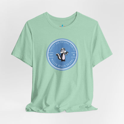 The Printify Miller Beach Skunks - Unisex Jersey Short Sleeve Tee is a gray T-shirt that features a circular blue logo at the center. Inside the logo, there is an illustration of a skunk with the text "Protect Our Habitat" and "Miller Beach Skunks" around the border, promoting environmental consciousness. The upper left part of the logo reads "Gary, IN.