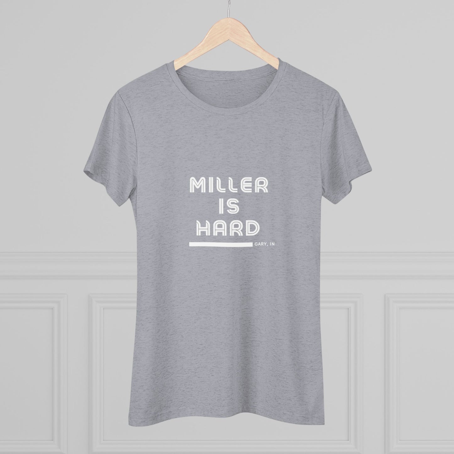 The Miller is Hard - Miller Beach Women's Triblend Tee by Printify features unique red coloring with white text that reads "MILLER IS HARD" and "GARY, IN" below, showcasing distinctive lettering spacing and alignment. Made from ultra-soft fabric, this shirt ensures a comfortable fit with a simple, casual design.