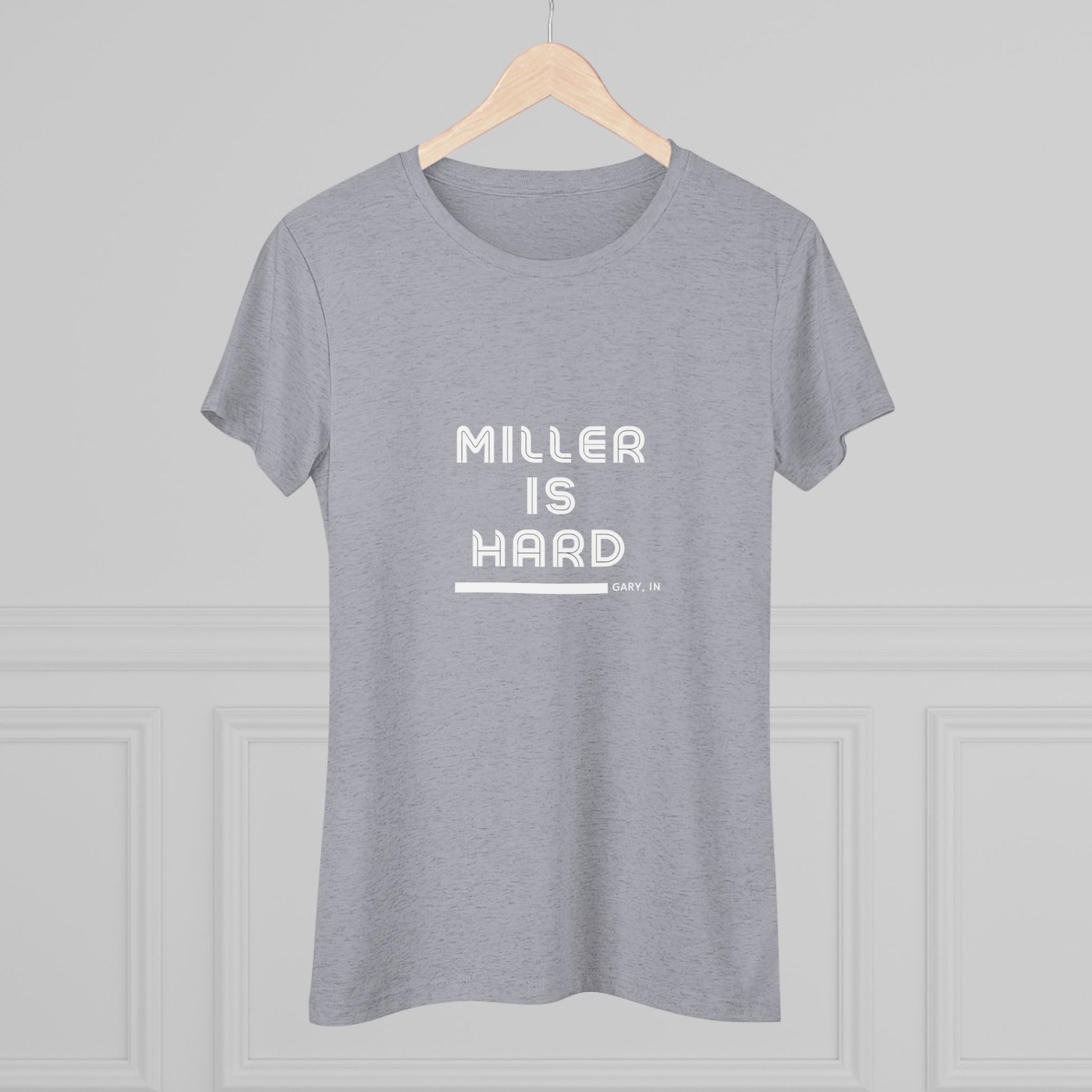 The Miller is Hard - Miller Beach Women's Triblend Tee by Printify features unique red coloring with white text that reads "MILLER IS HARD" and "GARY, IN" below, showcasing distinctive lettering spacing and alignment. Made from ultra-soft fabric, this shirt ensures a comfortable fit with a simple, casual design.