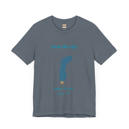 The Just the Tip - Miller Beach Unisex Jersey Short Sleeve Tee by Printify in yellow showcases text and a graphic design. The top displays "Just the tip" above a blue silhouette reminiscent of Indiana. At the bottom, it reads "Miller Beach" and "Gary, IN." Made from soft Airlume combed cotton, this tee offers both comfort and style.