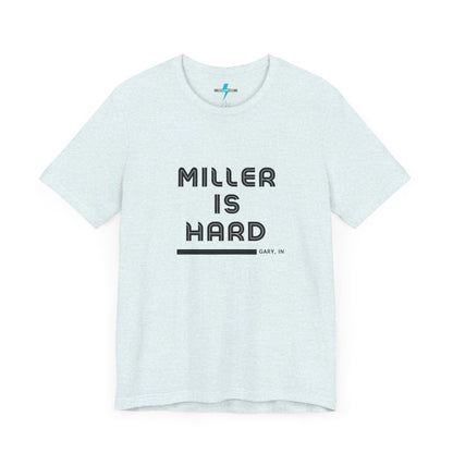 A unisex jersey short sleeve tee from Printify in burnt orange features the bold black text "MILLER IS HARD" on the chest, with "GARY, IN" written beneath in smaller black font. Perfect for showcasing Miller Beach's iconic spirit, this t-shirt is displayed against a plain white background.