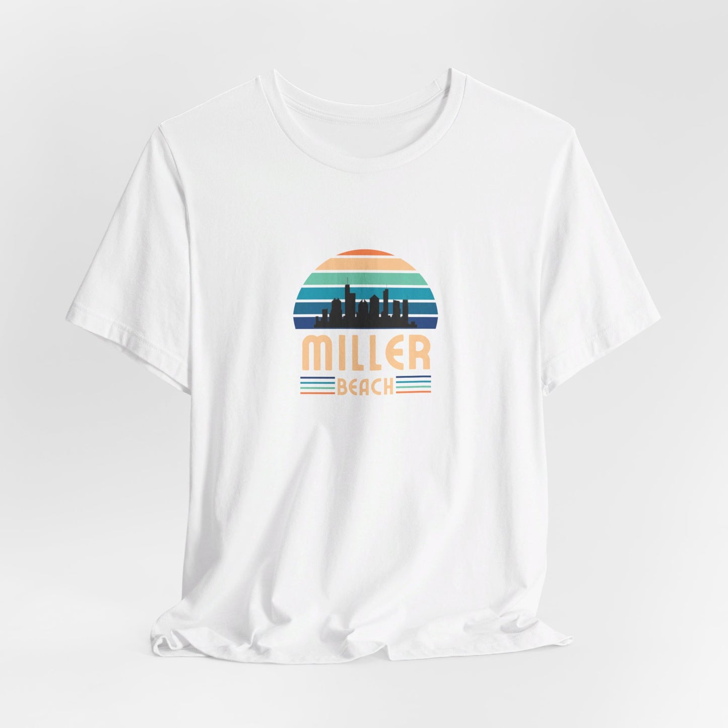 A brown unisex jersey short sleeve tee called "Miller Beach Chicago Skyline" from Printify features a vintage-style design with a sunset, the Chicago skyline, and "Miller Beach" in bold letters. The design incorporates shades of blue, orange, and yellow and is displayed against a plain white background.