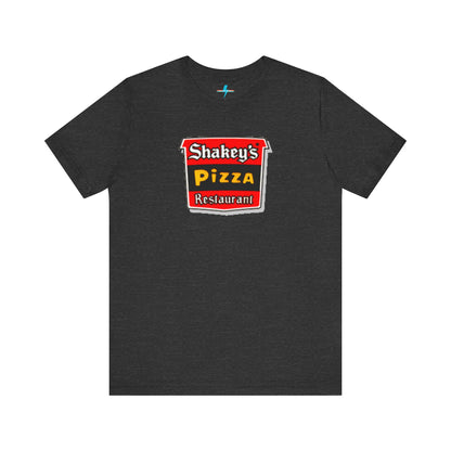 A black Shakey's Pizza - 1980s Retro Logo - Unisex T-Shirt by Printify hangs against a white background. The shirt features a colorful graphic with the text "Shakey's Pizza Restaurant" in white, yellow, and black lettering on a red background, resembling vintage pizza joints signage. This retro tee brings nostalgic vibes of classic pizzerias.