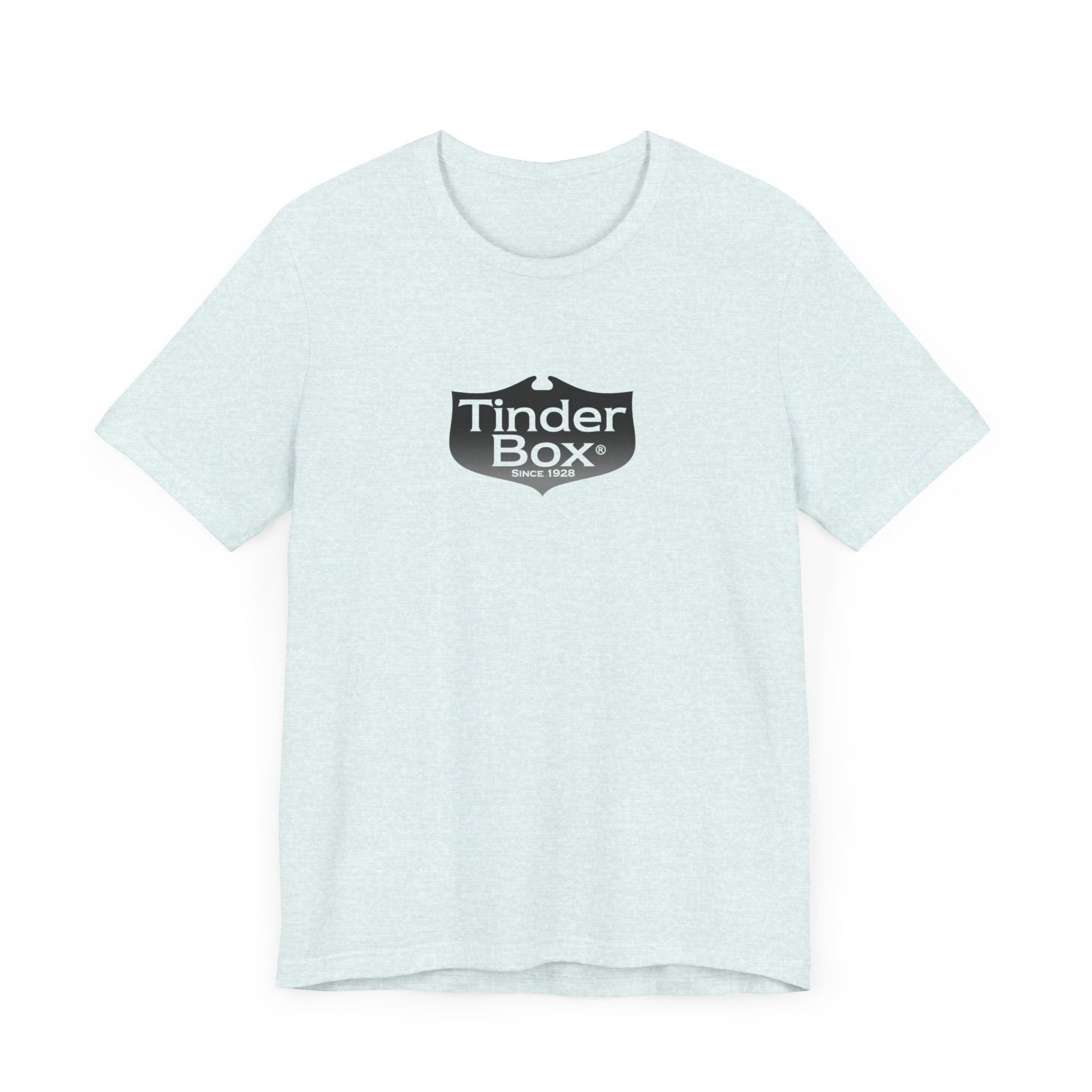 A light blue Printify "The Tinder Box 1980s" unisex jersey short sleeve tee featuring the "Tinder Box" logo in the center. The logo consists of a dark shield with the words "Tinder Box" in white text, with a small flame icon replacing the dot above the "i".