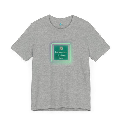 Introducing "The Lebanon Loop - Indiana" unisex jersey short sleeve tee by Printify. This green t-shirt features a graphic of a road sign displaying "39 Lebanon Lizton 1 MILE" within a slightly glowing square frame. It's crafted from 100% Airlume cotton and photographed flat on a white background.