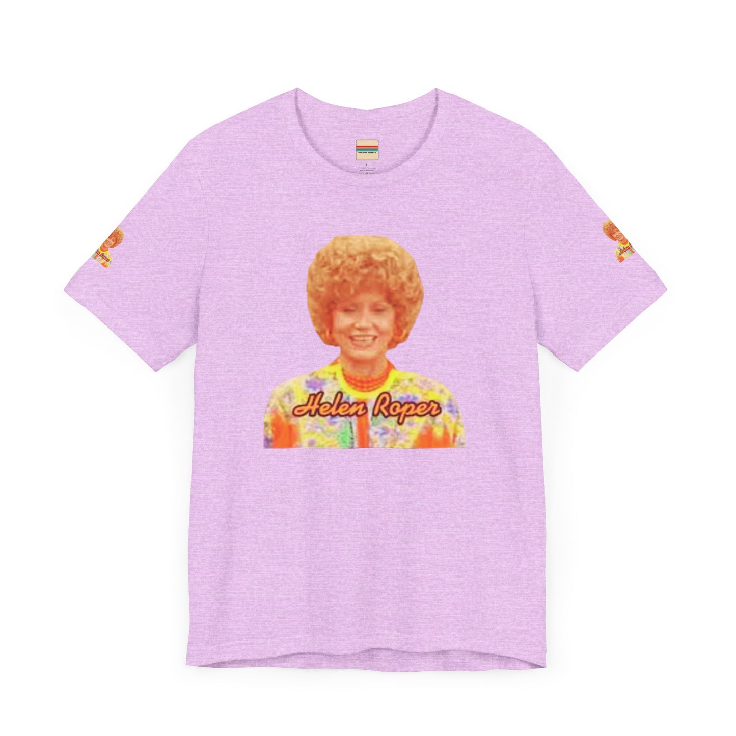 A lavender-colored Helen (Mrs.) Roper Three's Company - Unisex Jersey Short Sleeve Tee by Printify is hanging on a wooden hanger against a white background. This T-shirt features an image of a smiling person with curly hair wearing a colorful blouse, with the text "Helen Roper" underneath the image. Both sleeves have identical designs, making it perfect Three's Company merchandise.