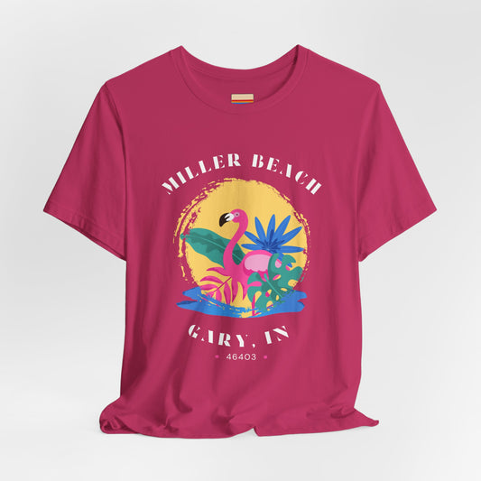 Introducing the Miller Beach Flamingo - Unisex Jersey Short Sleeve Tee by Printify! This bright red t-shirt features a colorful tropical design with a flamingo, palm leaves, and abstract floral elements. The text around the design reads "Miller Beach, Gary, IN, 46403" in white font. Show your Miller Beach pride with this vibrant piece!