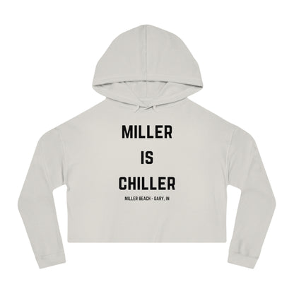 A white Women's Cropped Hooded Sweatshirt by Printify, featuring the phrase "MILLER IS CHILLER" printed in bold black letters on the front. Below the phrase, it says "MILLER BEACH • GARY, IN" in smaller black text. The SoCool Shirts hoodie includes a drawstring hood and long sleeves.