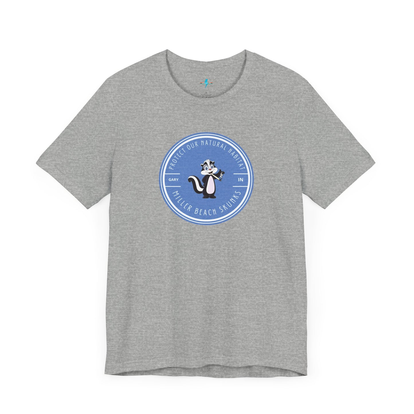 The Printify Miller Beach Skunks - Unisex Jersey Short Sleeve Tee is a gray T-shirt that features a circular blue logo at the center. Inside the logo, there is an illustration of a skunk with the text "Protect Our Habitat" and "Miller Beach Skunks" around the border, promoting environmental consciousness. The upper left part of the logo reads "Gary, IN.