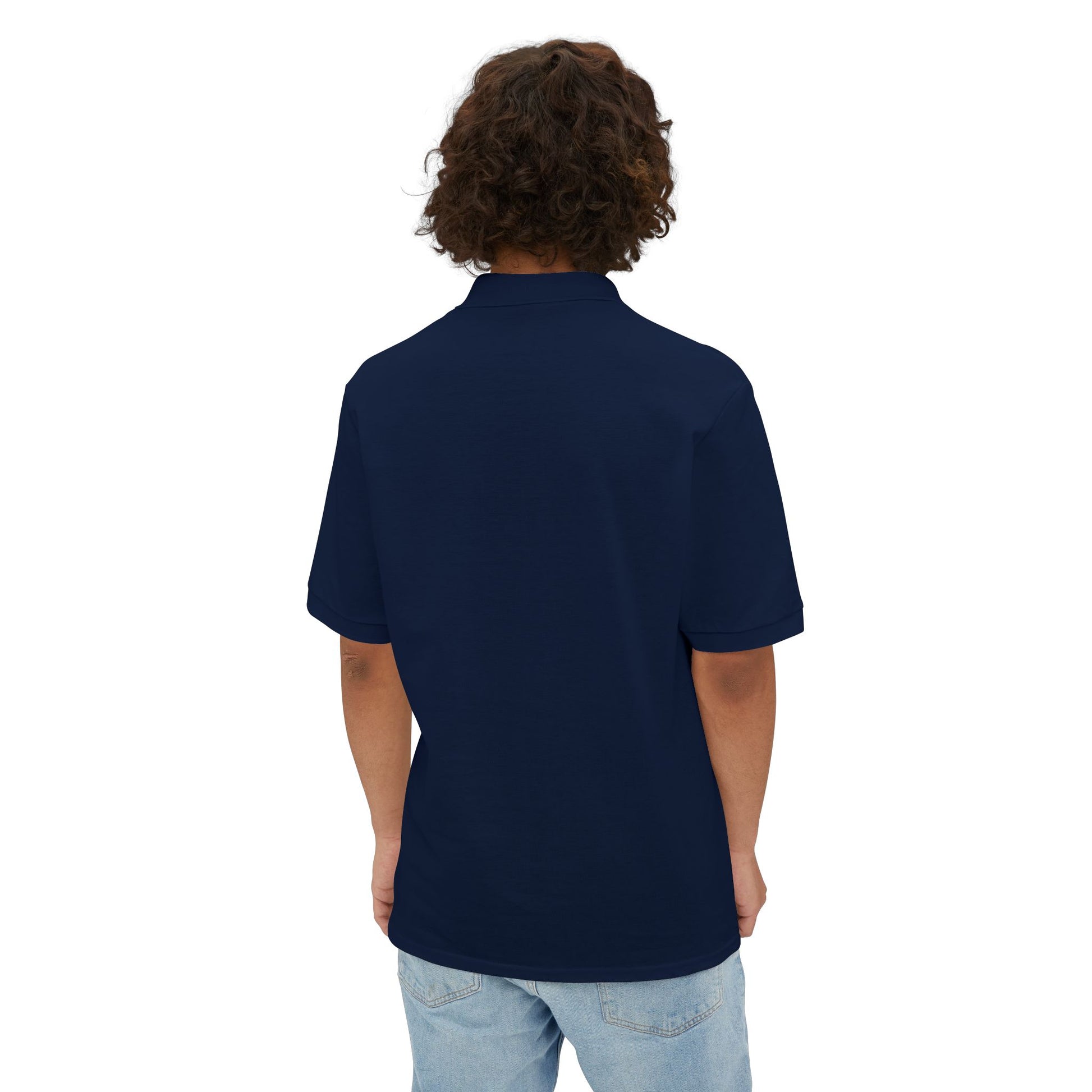 A person with curly hair wearing a navy blue Printify Braggin' Dragon - 1980s Sears Men's Piqué Polo, featuring a small embroidered dragon logo on the left chest, smiles against a plain white background.