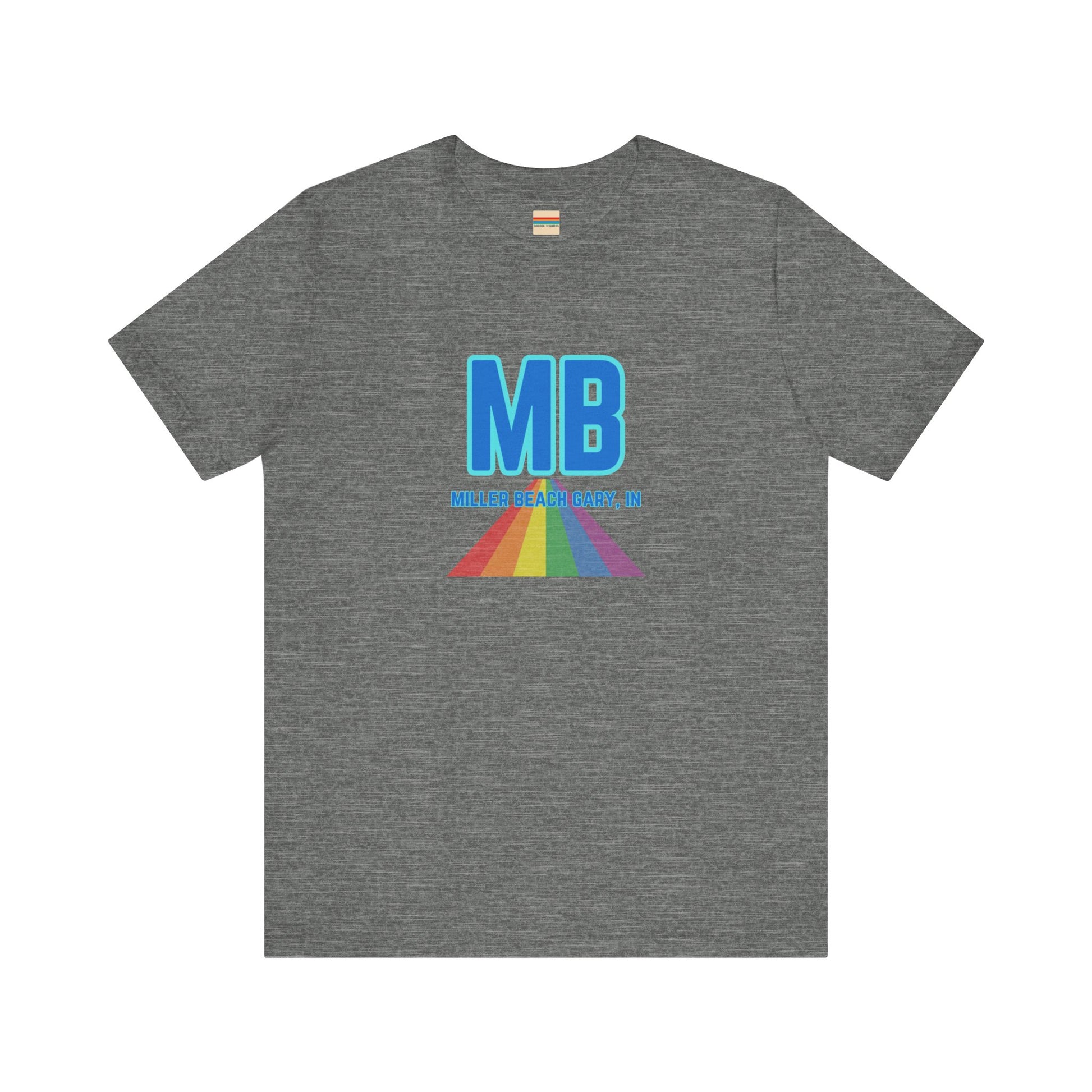 The Miller Beach Pride - Unisex Jersey Short Sleeve Tee by Printify is a white shirt made from 100% Airlume combed cotton. It showcases a design with large, bold blue letters "MB" at the top. Beneath it, the text "MILLER BEACH GARY, IN" is written in blue. A colorful, triangular rainbow graphic extends downward from the text, symbolizing Miller Beach pride.